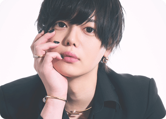 金と黒の装飾的な背景で撮影された山田一郎のポートレート写真。黒髪とスーツ姿が映える高級感のあるプロフィールイメージ。