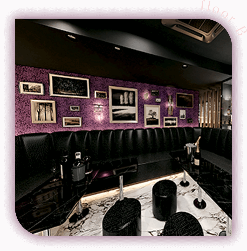 Bのラウンジエリア。紫の壁に多くのフレームアートが飾られ、黒いソファと大理石テーブルが高級感を演出しています。